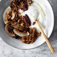 a bowl with granola, coconut yogurt and a spoon