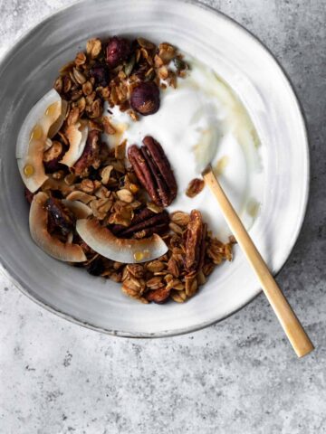 a bowl with granola, coconut yogurt and a spoon