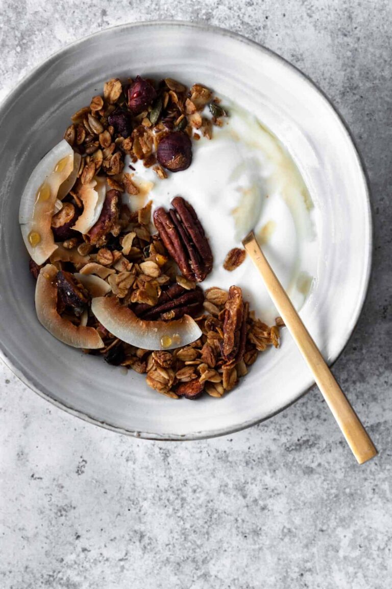 a bowl with granola, coconut yogurt and a spoon