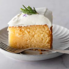 a small grey plate with a slice of lemon cake and a fork