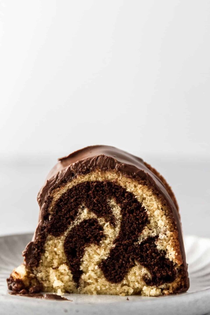 A sliced of marble cake with chocolate cream on top