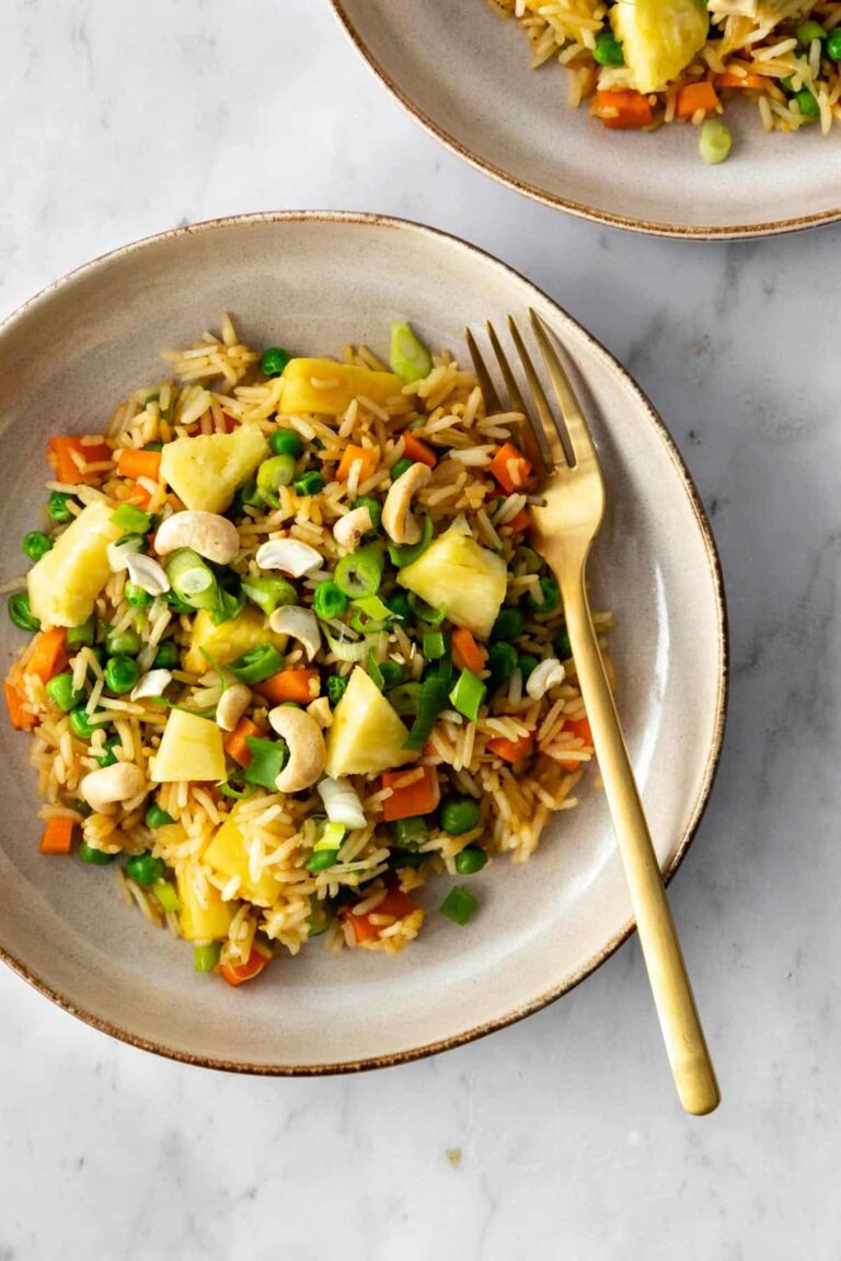 Thai pineapple fried rice served on a plate with a gold fork on the side