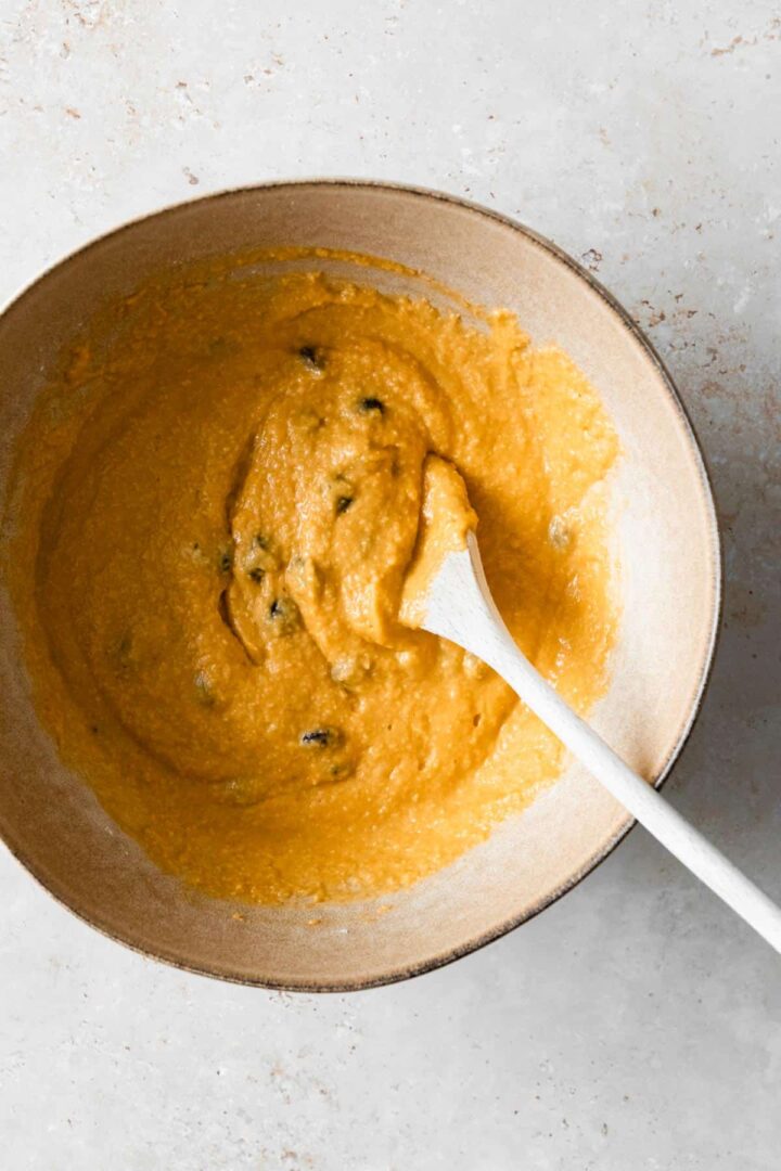 pumpkin bread batter mixed o a large mixing bowl with a spoon