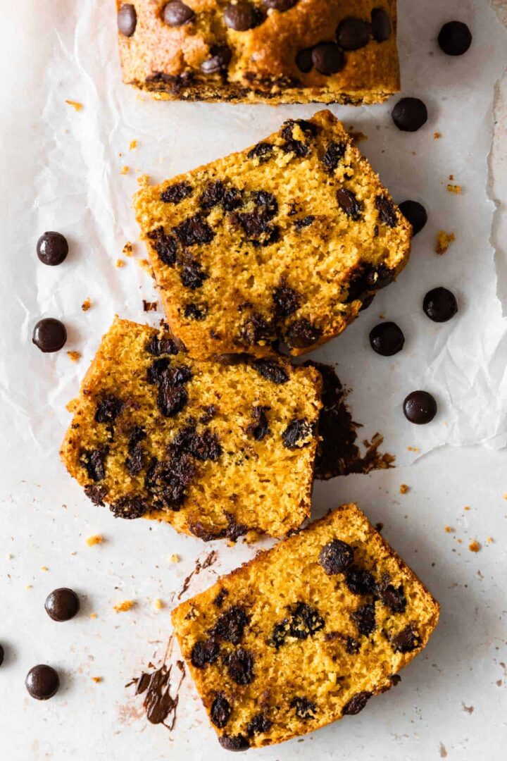 three slices of chocolate chip pumpkin bread with chocolate chips on the table