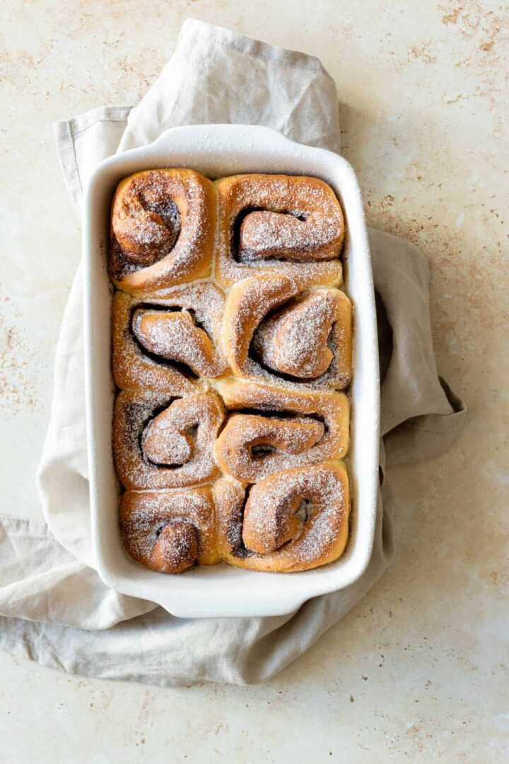 a baking dish with cinnamon rolls sprinkled with sugar on top