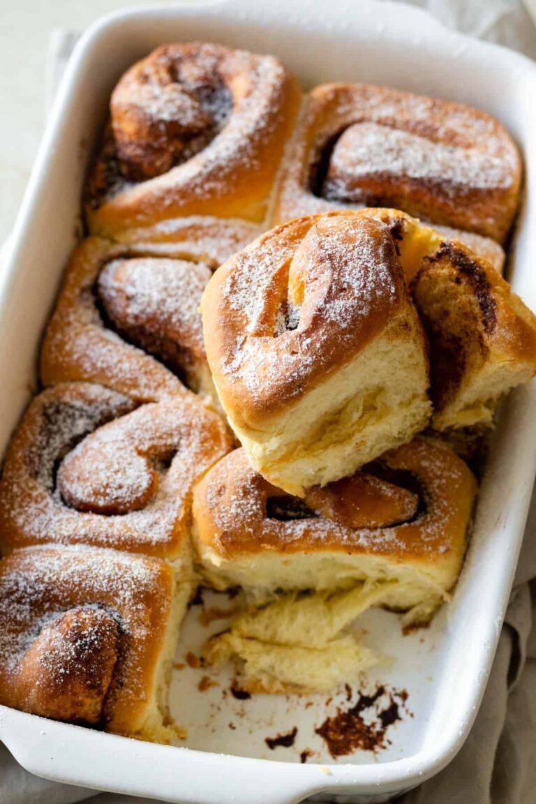 a baking dish with cinnamon rolls sprinkled with sugar on top