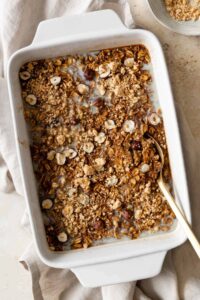 pumpkin baked oatmeal on a baking dish with a gold spoon on the side