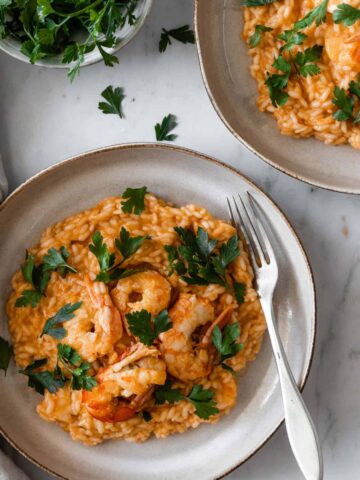 a plate served with shrimp risotto garnished with parsley