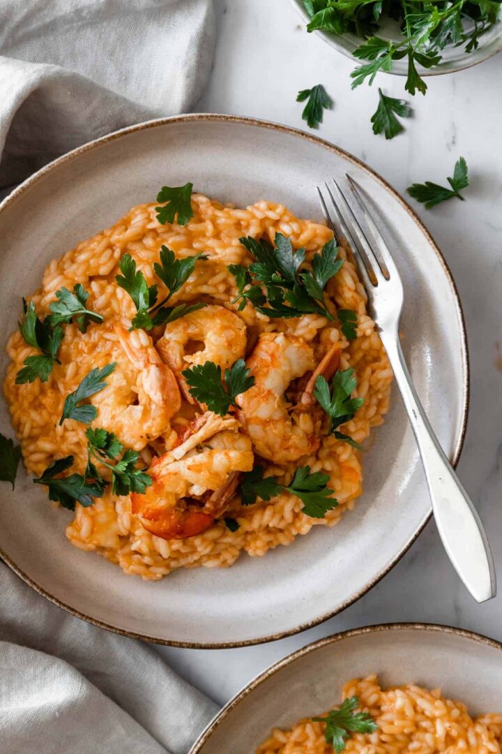a plate served with arborio rice, shrimp and parsley