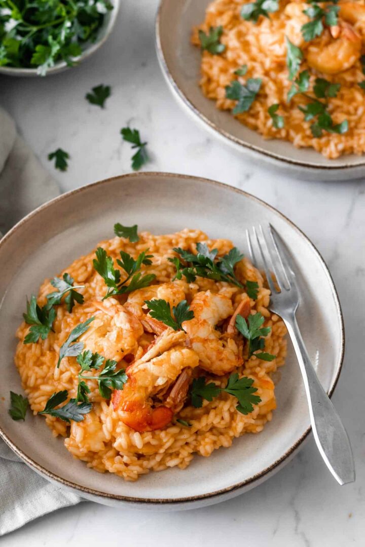 two plates served with shrimp risotto and garnished with parsley