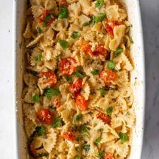 baked feta pasta on a baking dish with chopped basil on top