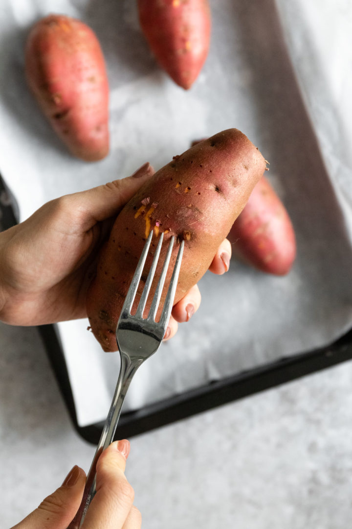 pricking a sweet potato with a fork