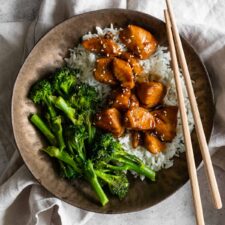one bowl served with chicken teriyaki, rice, broccolini and garnished with sesame seeds