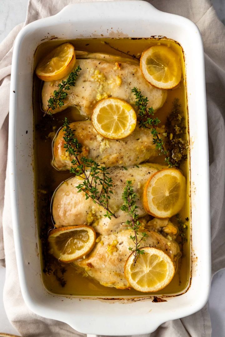close up of baked lemon chicken on a baking dish