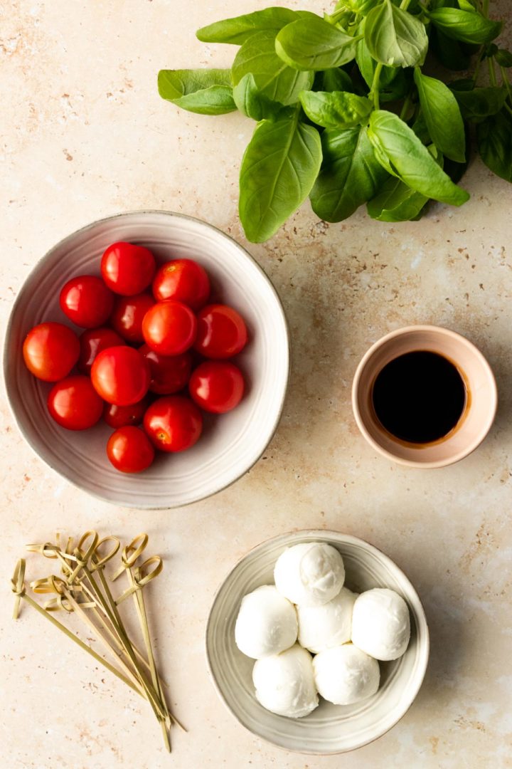 ingredients for Caprese skewers. Cherry tomatoes, mozzarella, fresh basil and balsamic glaze