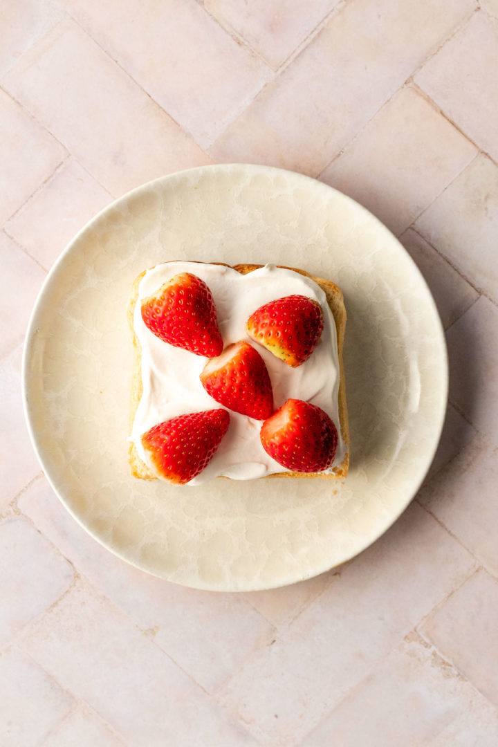 strawberries and whipped cream on top of bread