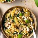 one plate served with pasta, zucchini, mushrooms, spinach, crumbled feta and walnuts.