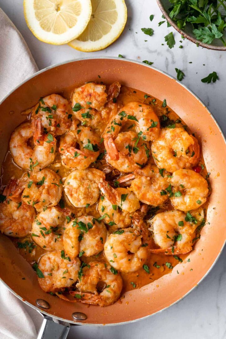 fried shrimp inside a pan with chopped parsley on top