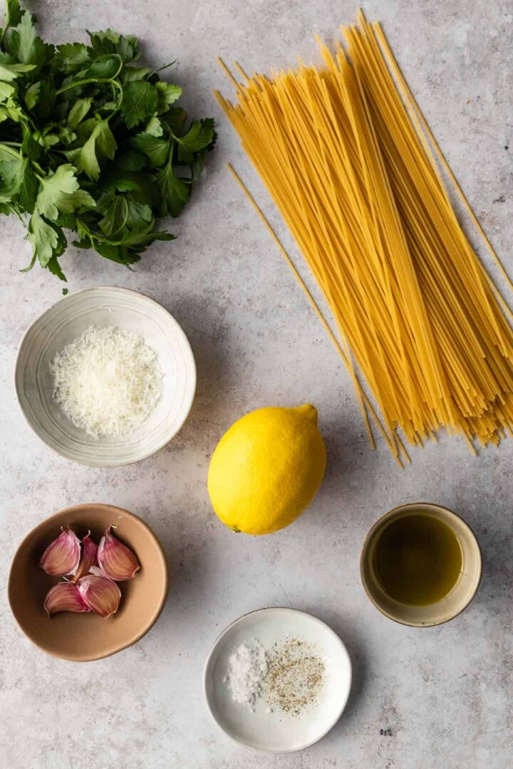ingredients to make lemon pasta on top of a board