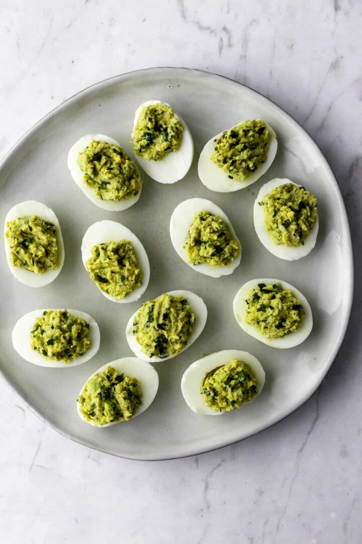 a plate with boiled egg halves with avocado