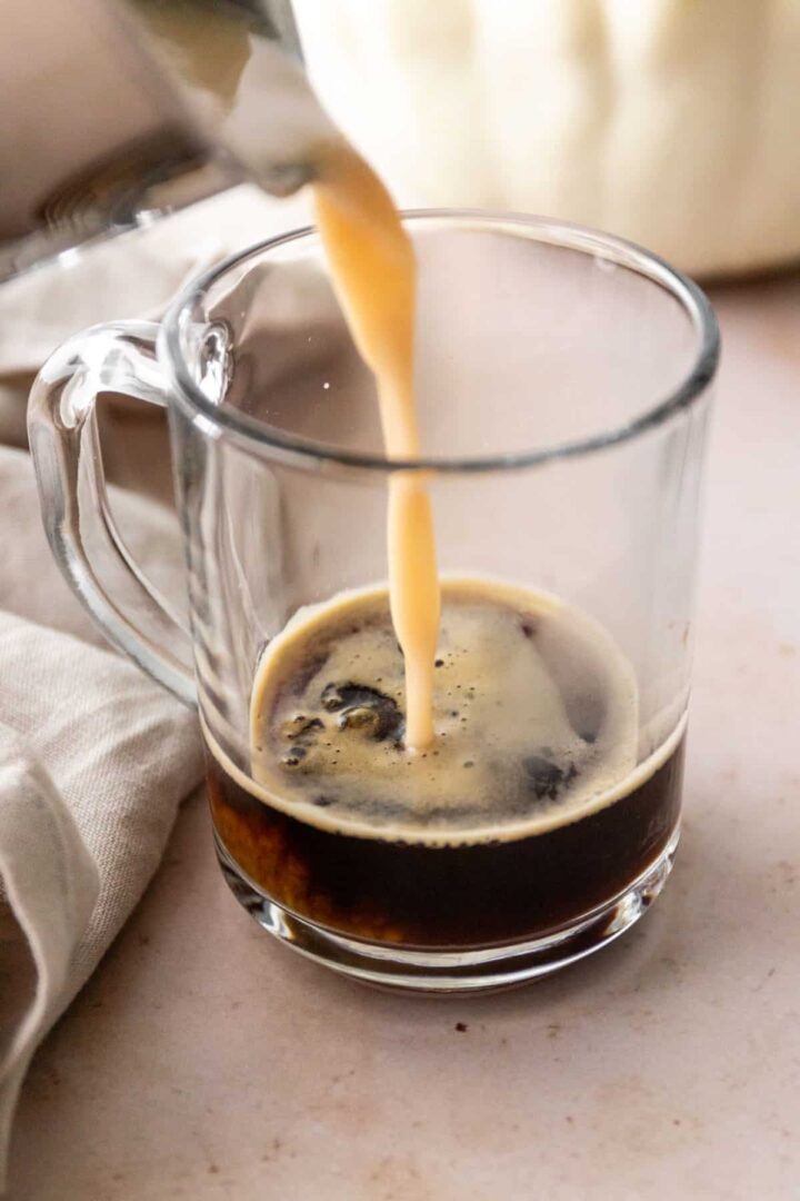 coffee being poured over a glass mug