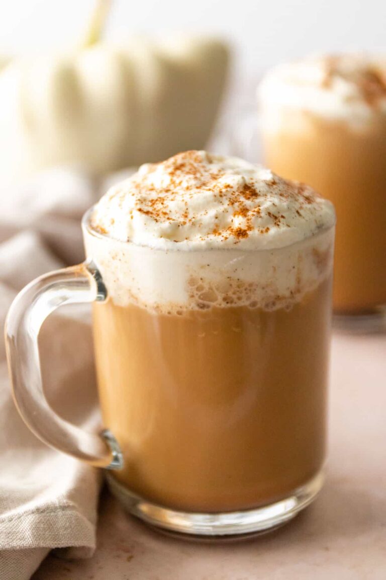 a glass mug with milk, whipped cream and cinnamon