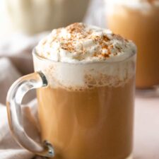 a glass mug with milk, whipped cream and cinnamon