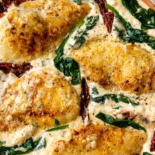 close-up for Tuscan chicken with sun-dried tomatoes, spinach leaves and a creamy and cheesy sauce