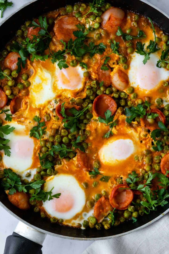 one-skillet with eggs, peas, chorizo and coriander on top