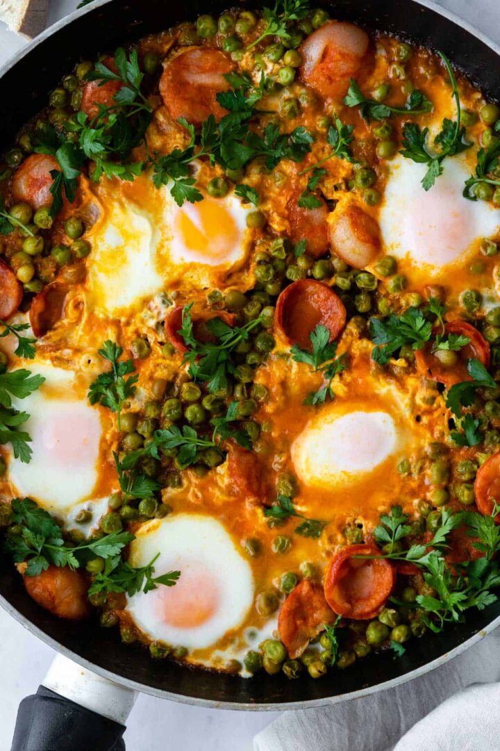 one pan with eggs, peas, chorizo, and coriander on top