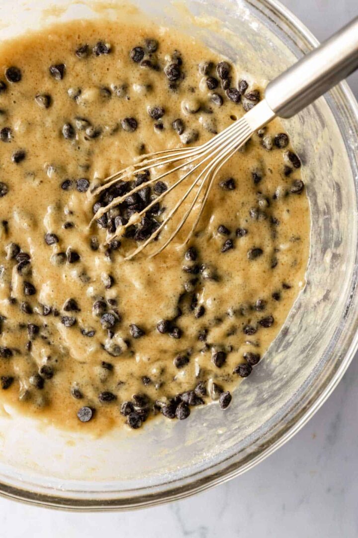 a large bowl of banana bread batter with chocolate chips
