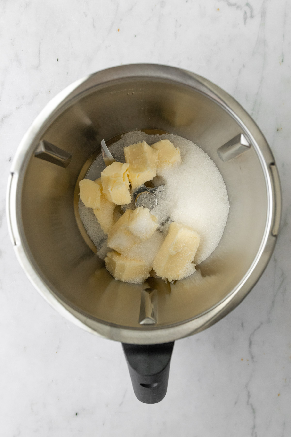 a Thermomix mixing bowl with butter and sugar inside